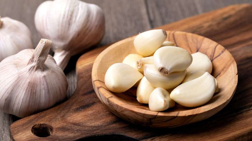 Garlic Cloves and Garlic Bulbs on Wooden Table
