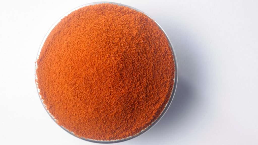 Red Chili Powder in a Bowl on a White Background